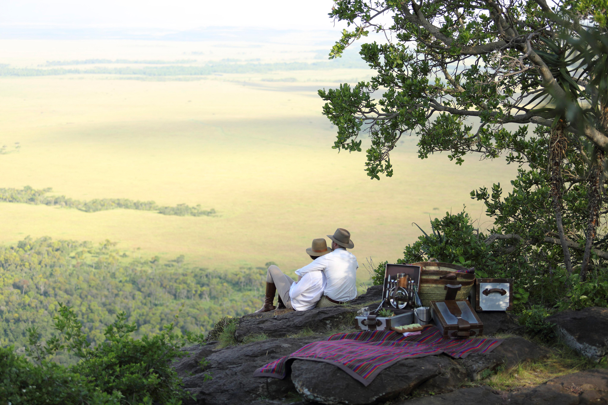 couple on a picnic date on a hill overlooking mara at Angama Mara Kenya Masai Mara