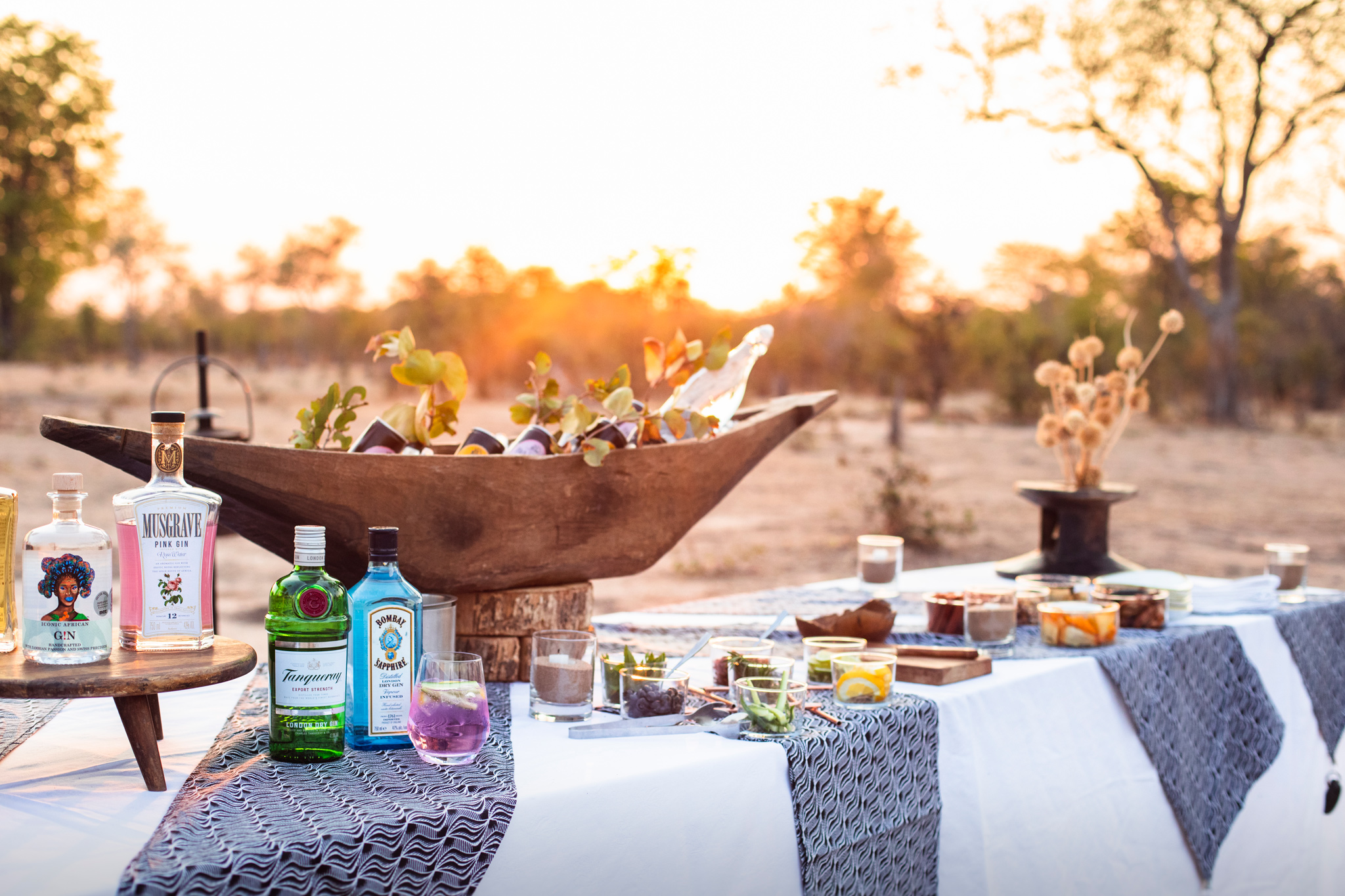 sundowners on a table in the bush at sunset by  Chichele Presidential Lodge Zambia