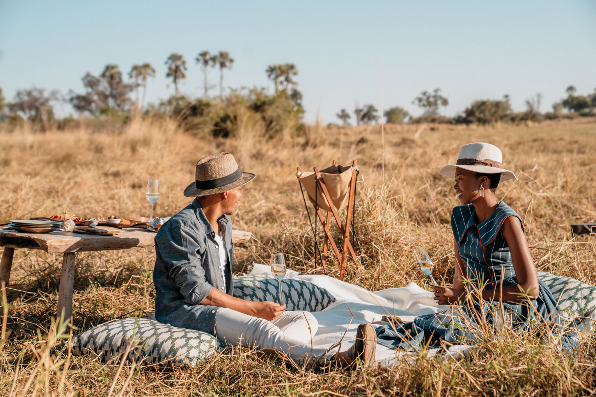 couple sitting on short grass of delta having a picnic at eagle island lodge
