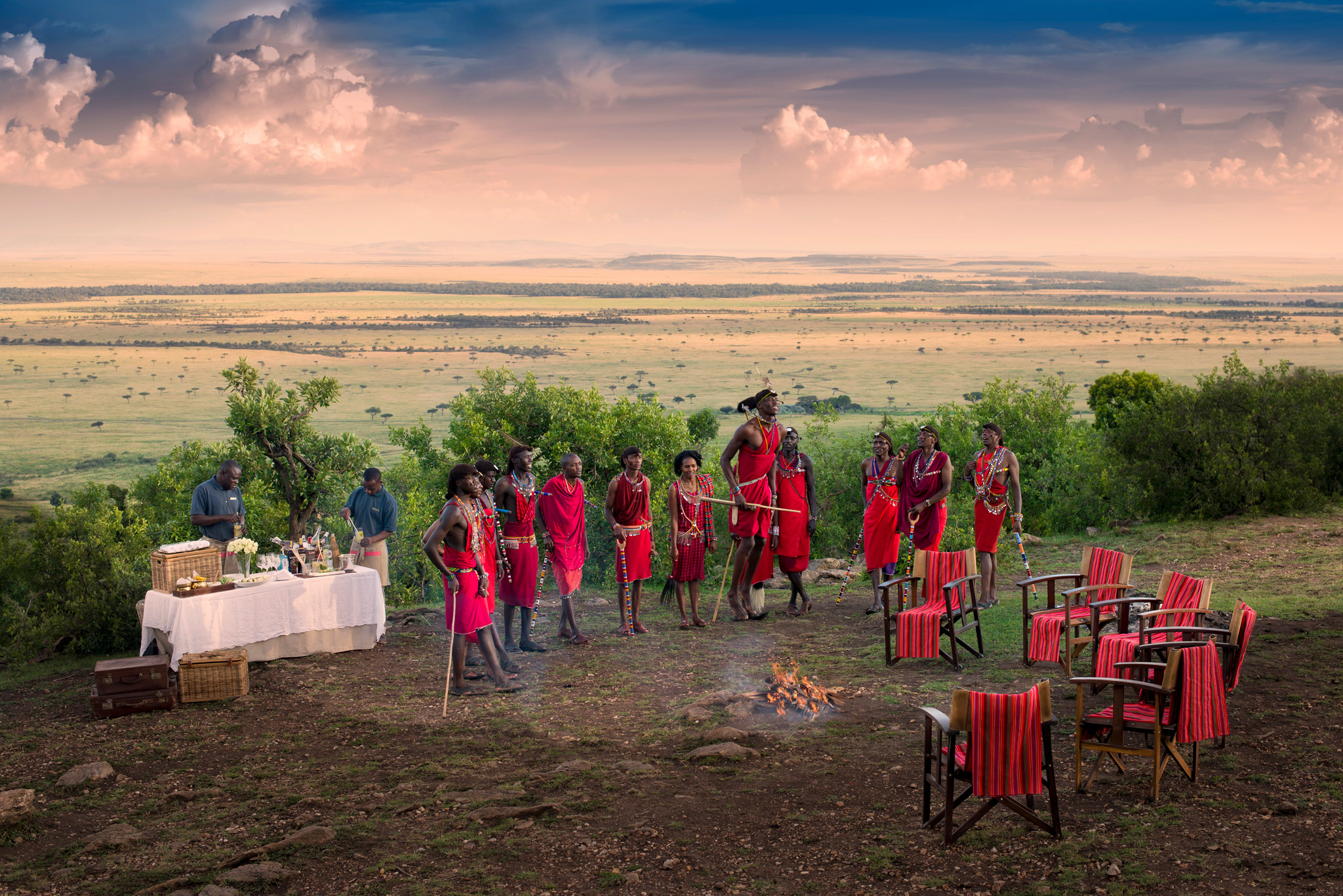 Masai men by fireplace boma to entertain guests of andbeyond Bateleur camp Kenya Masai Mara