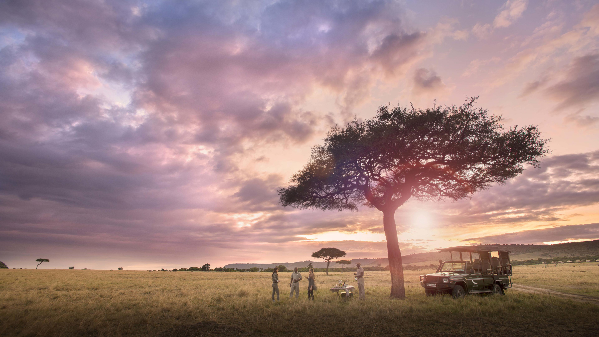 sundowners under a tree on plains at sunset by andbeyond Bateleur camp Kenya Masai Mara