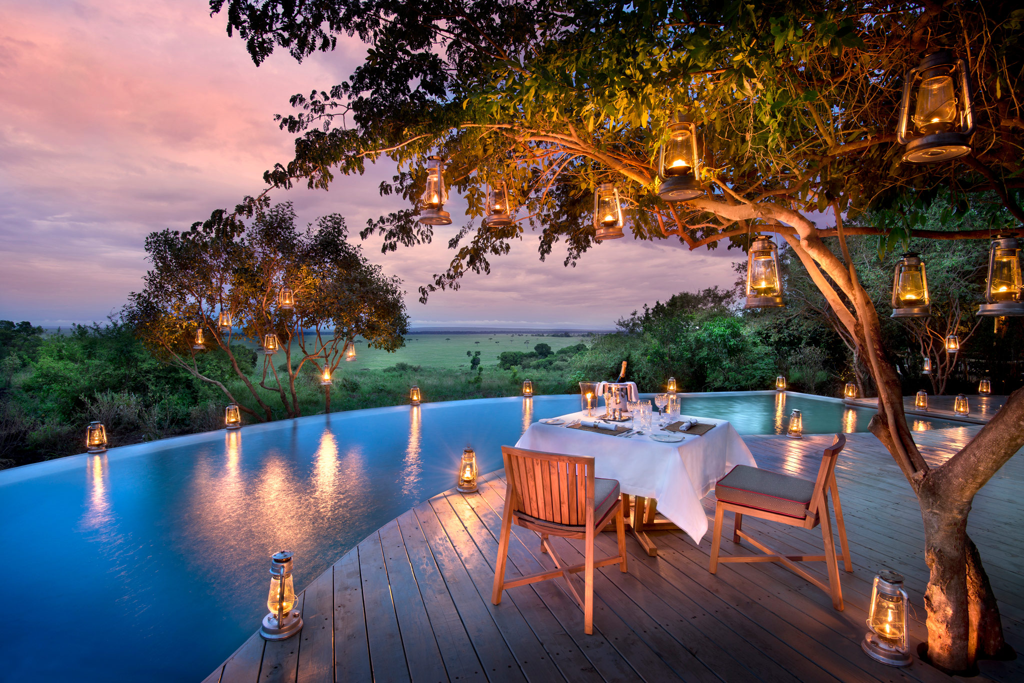 dinner setting at night on deck by pool of andbeyond Bateleur camp Kenya Masai Mara