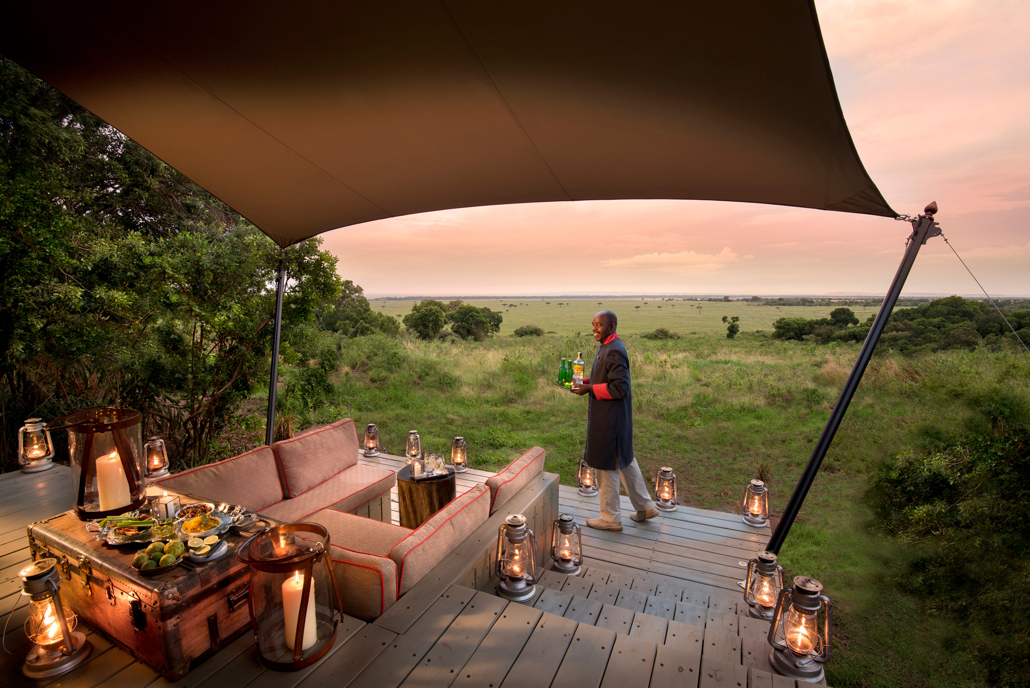 staff bringing drinks to suite deck by andbeyond Bateleur camp Kenya Masai Mara