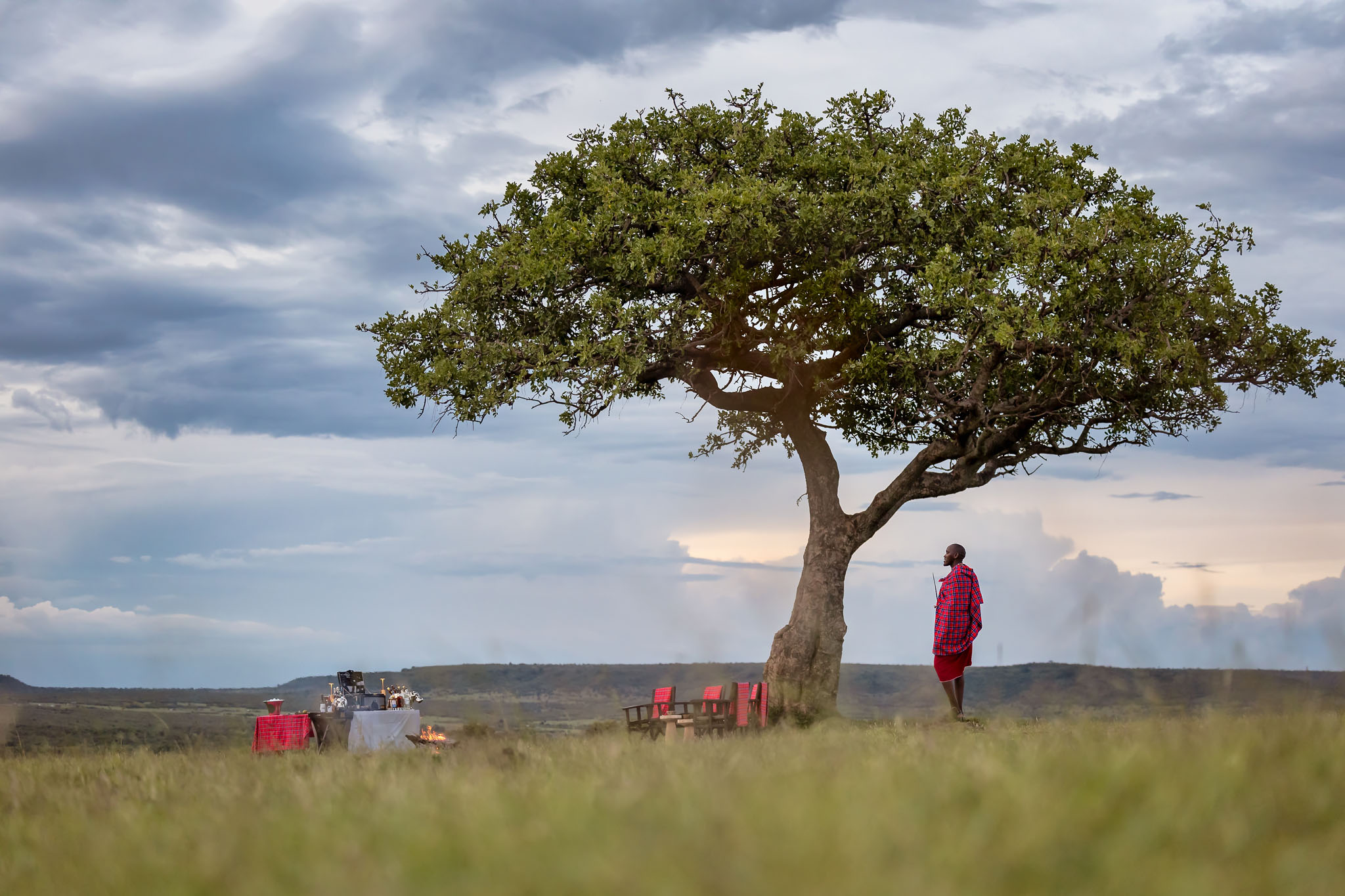 sundowners on the plains of the mara with a masai man at the JW Marriot Masai Mara Kenya
