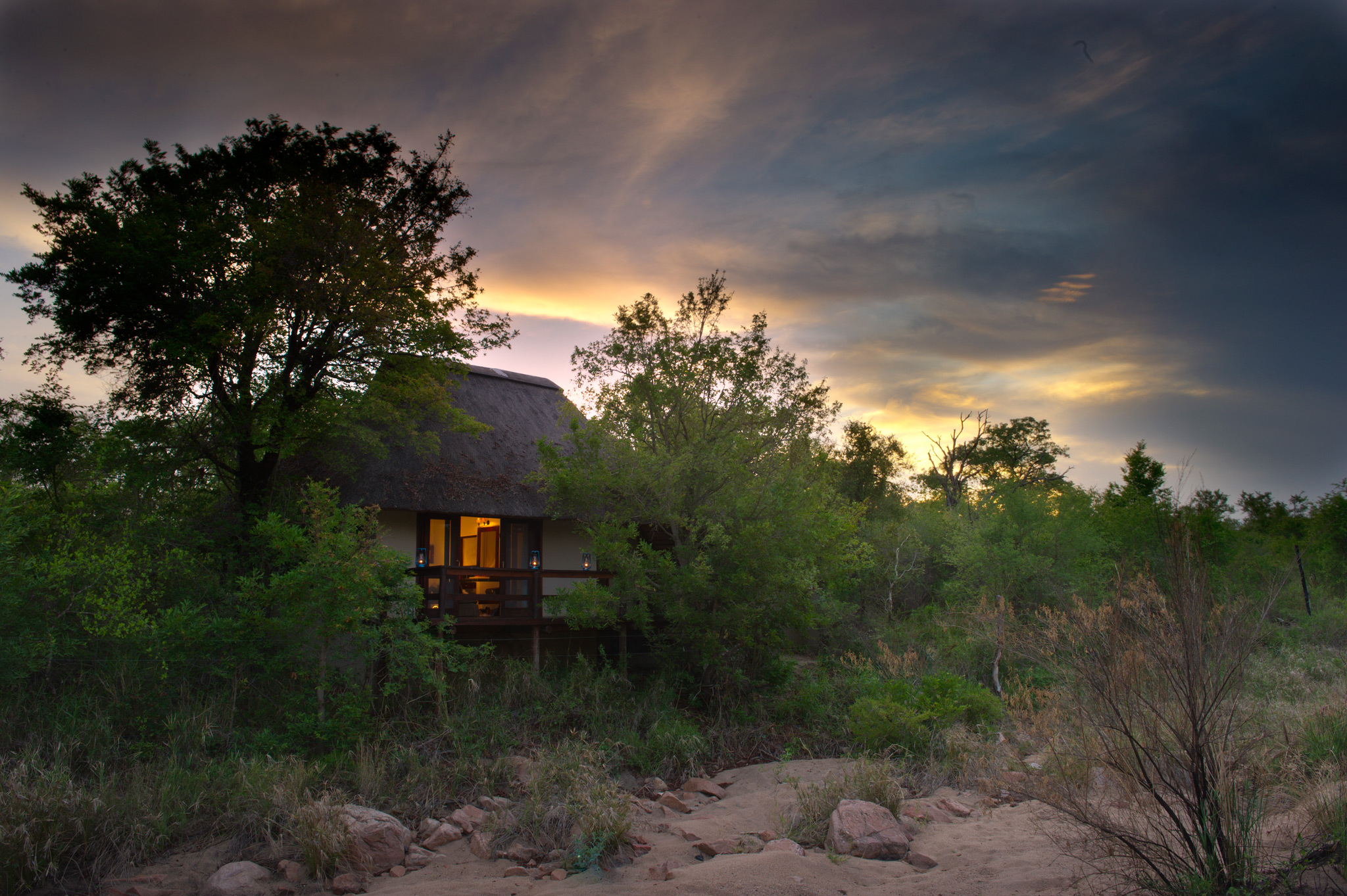 evening view of suite from riverbed at little bush camp sabi sabi