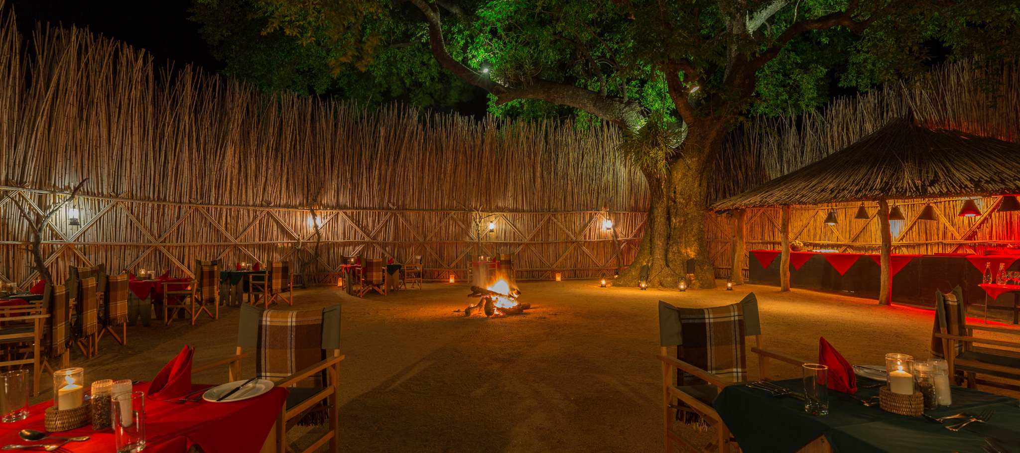 fireplce boma at night with tables set for supper at MalaMala Main Game lodge