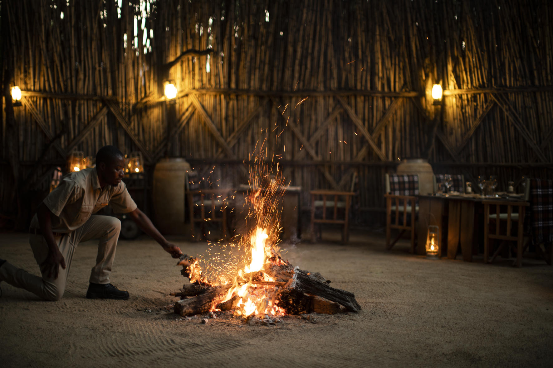 fire stoking in fireplace boma at late afternoon by MalaMala game lodge