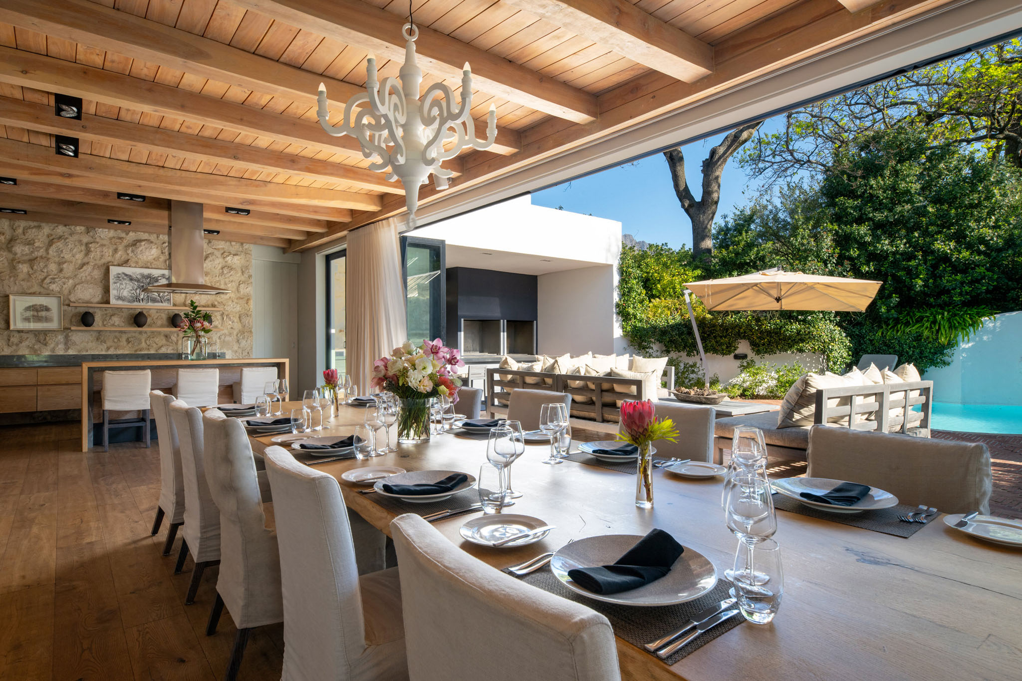 long dining table with chairs set with open sliding windows at Mont Rochelle Luxury Hotel in Franschhoek