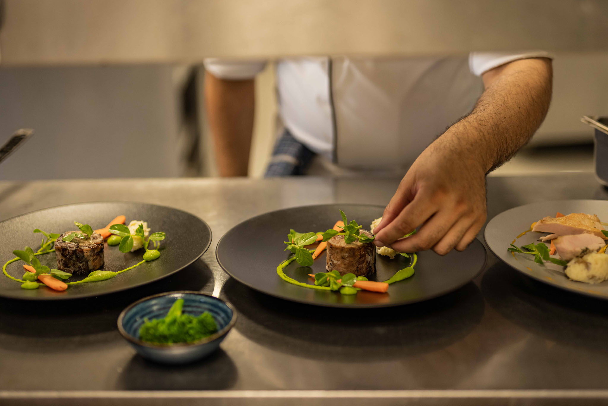 gourmet food served from kitchen by chef on black plates at Mont Rochelle Luxury Hotel in Franshoek