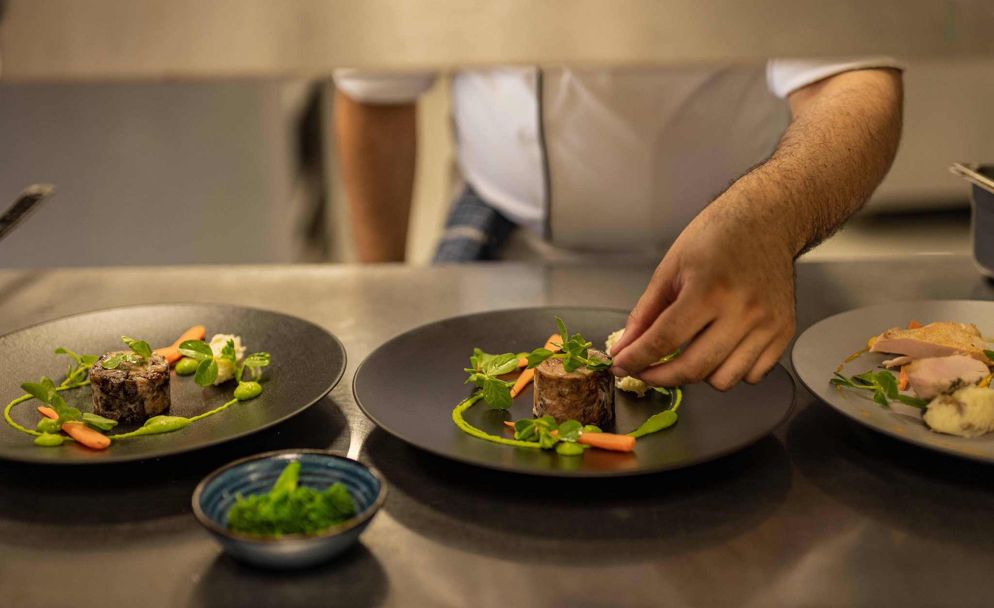 gourmet food served from kitchen by chef on black plates at Mont Rochelle Luxury Hotel in Franshoek