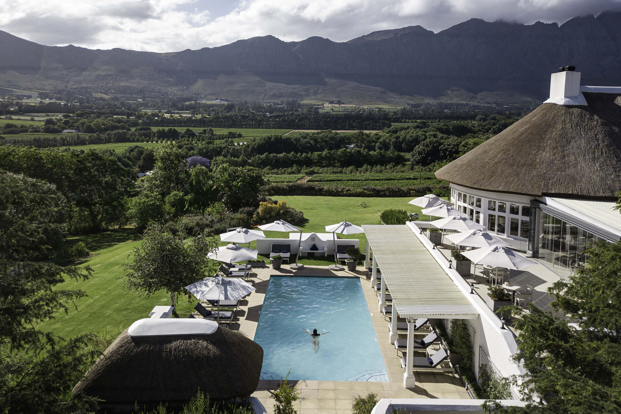aerial view of hotel and pool with mountain backdrop at Mont Rochelle Luxury Hotel in Franshoek
