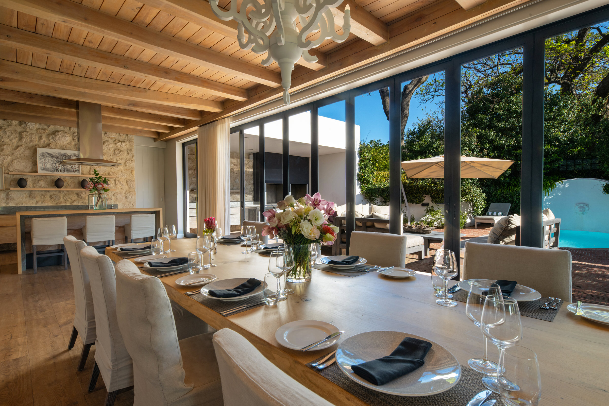 dinner table set for guests in fron of wndows of pool deck at mont rochelle