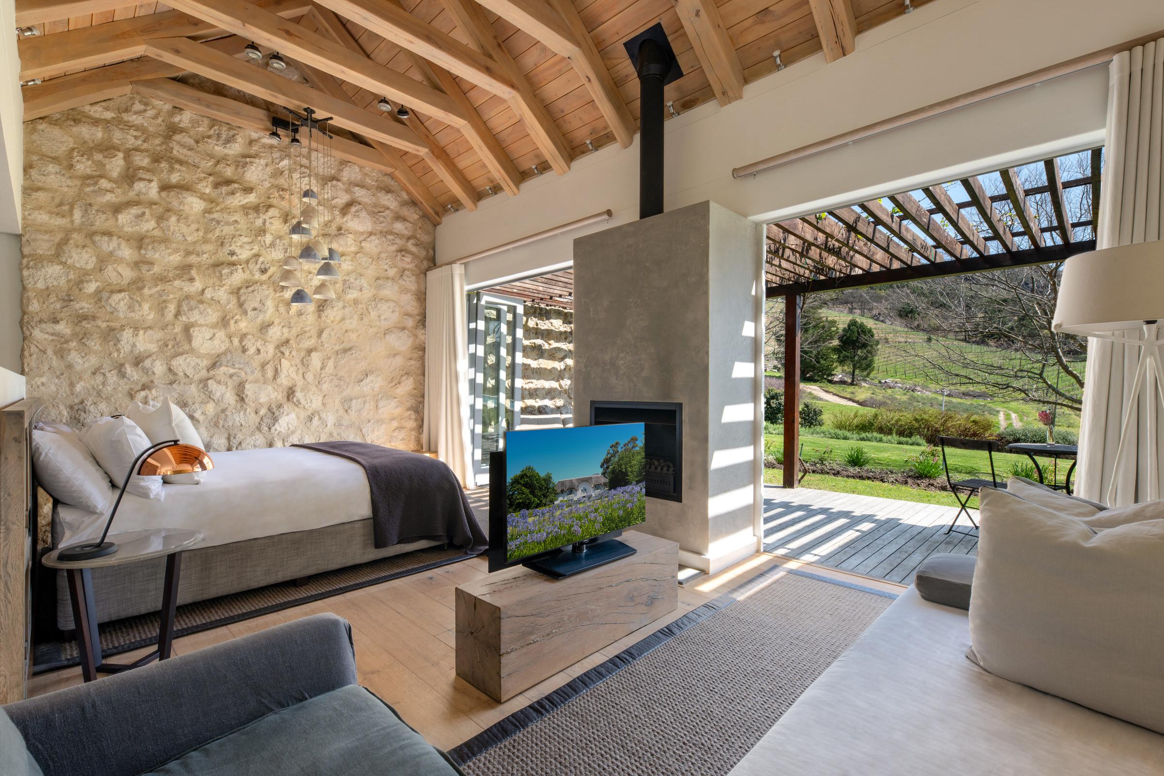 interior of room with tv, bed and views of winelands at mont rochelle