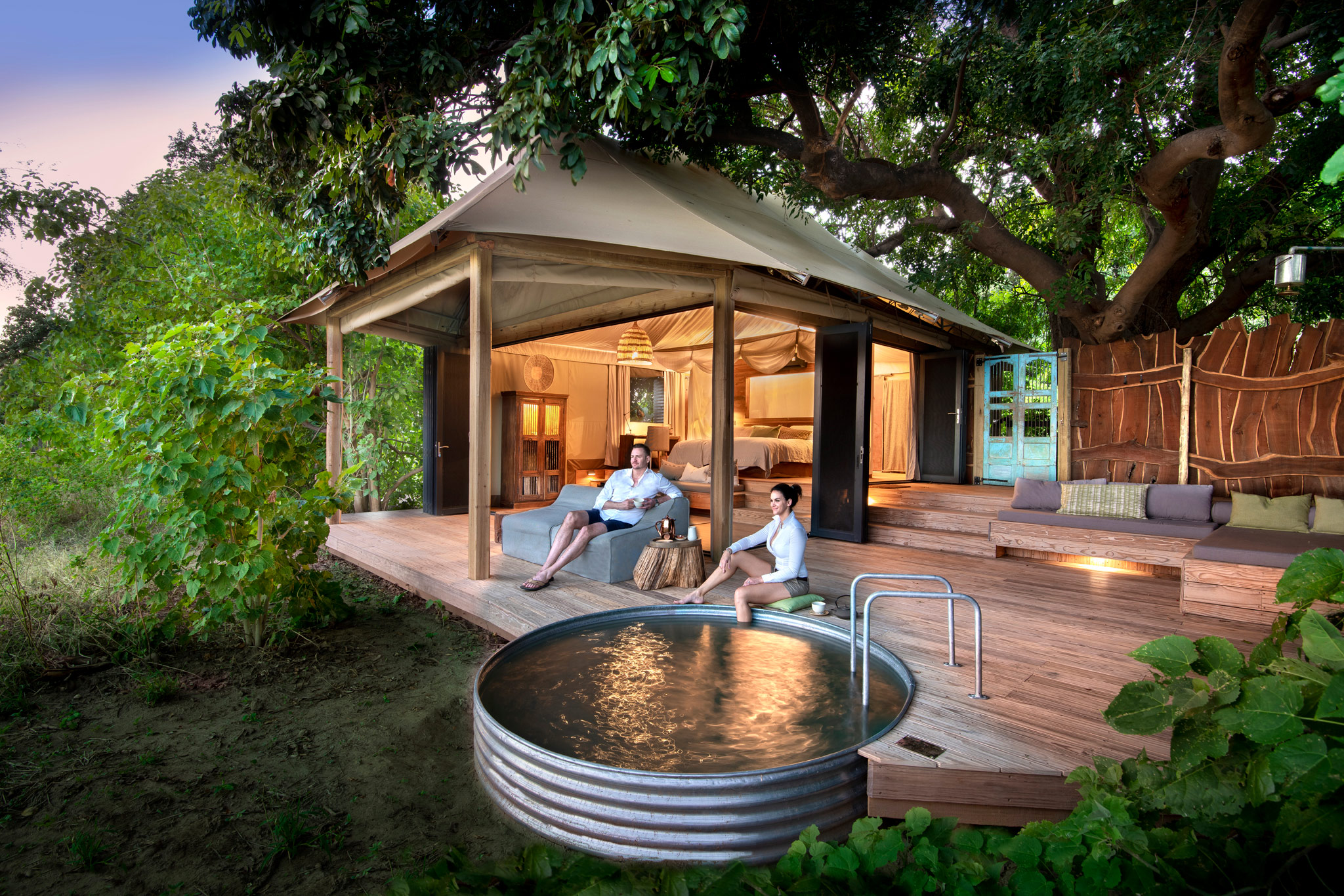 couple outside suite on deck by splash pool at Nyamatusi Camps Mana Pools Zimbabwe 