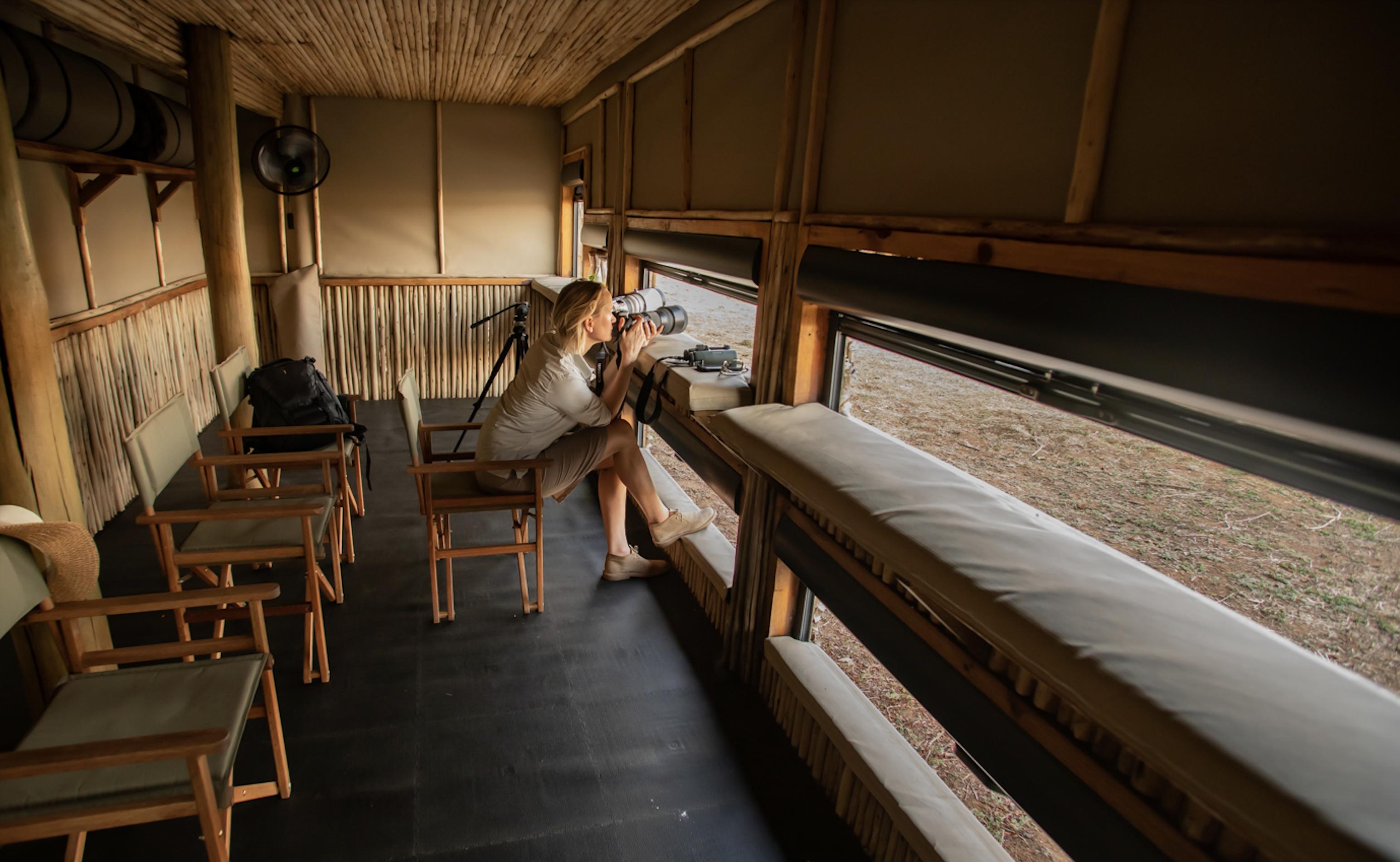 lady in a photographic hide by puku ridge camp zambia