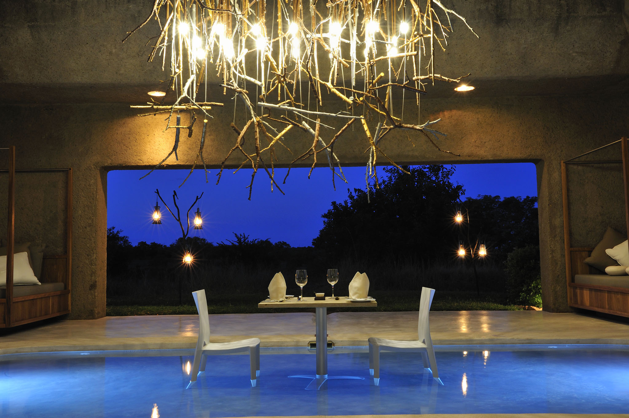 pool bar with table set for supper by sabi sabi earth lodge