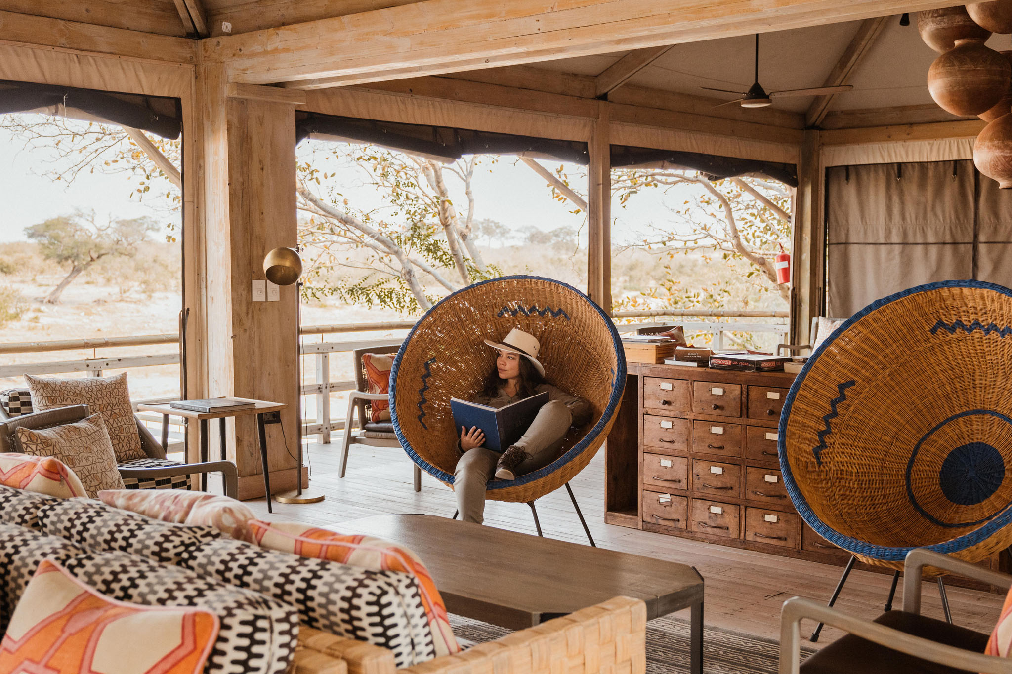 guest sitting in african chair reading on deck at savute elephant lodge