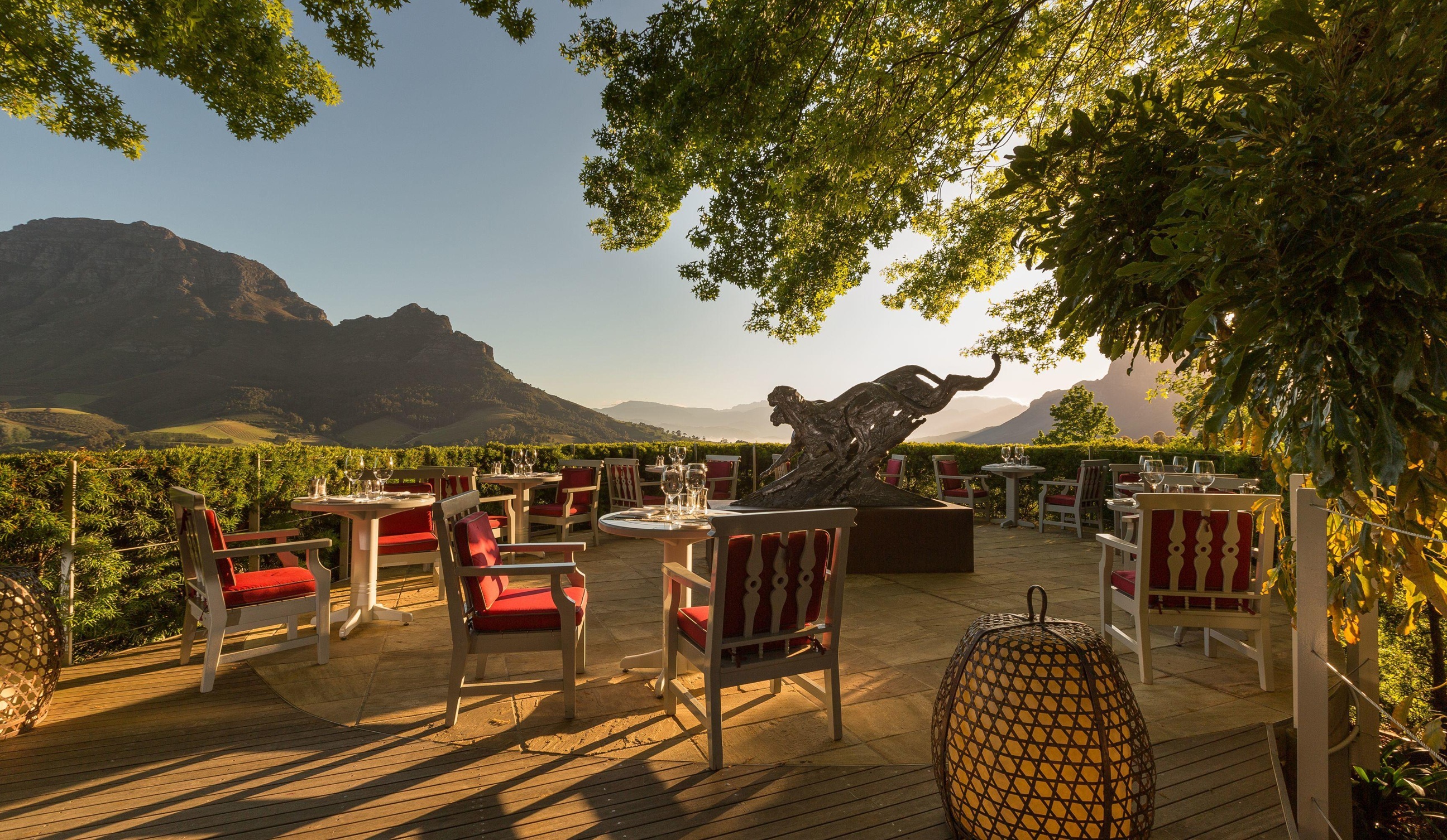 entertainment area with tables and chairs on deck at Delaire Graff luxury Wine estate in Franshoek with mountain in background