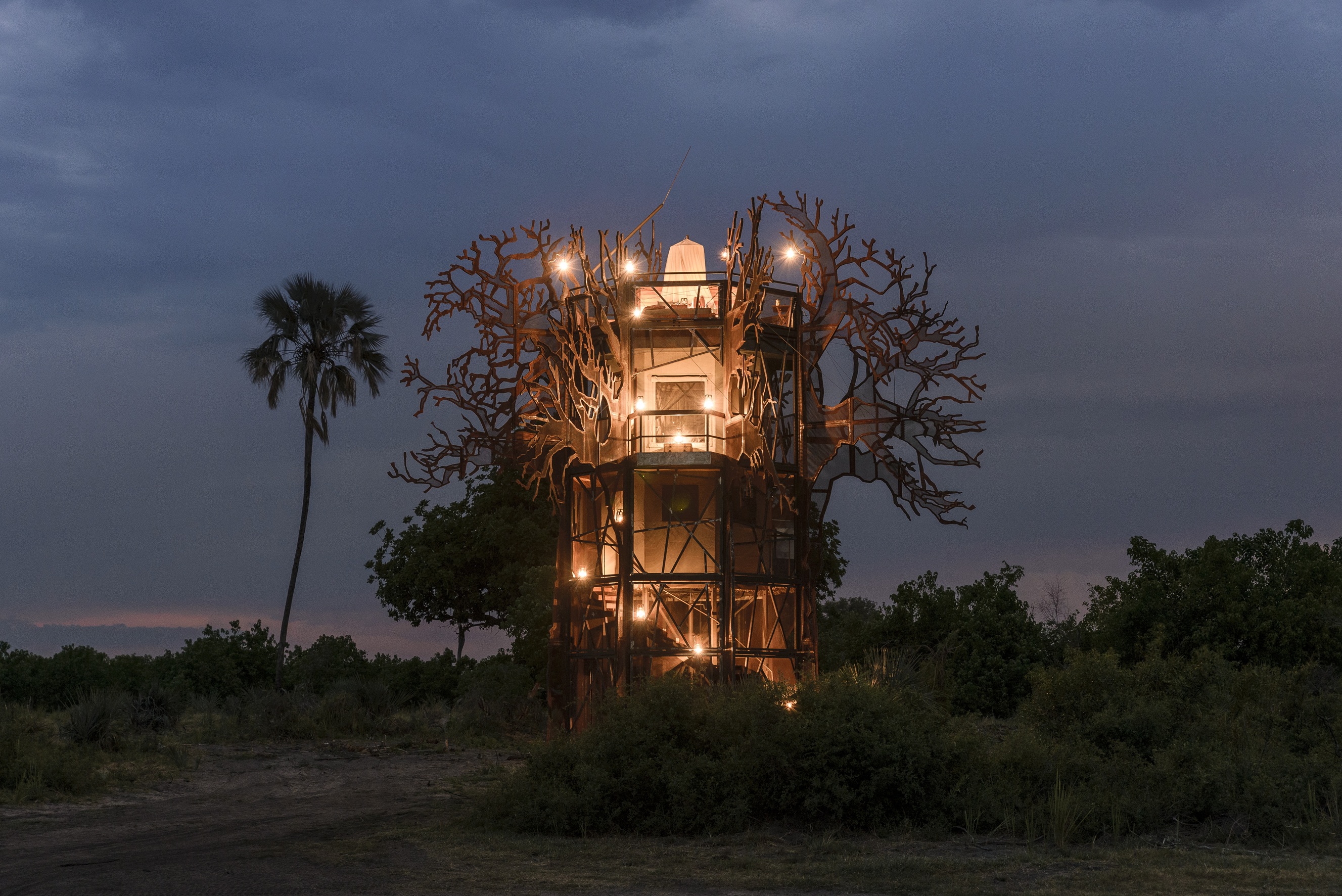 a nighttime image of the tree house illuminated at Xigera safari lodge in Botswana