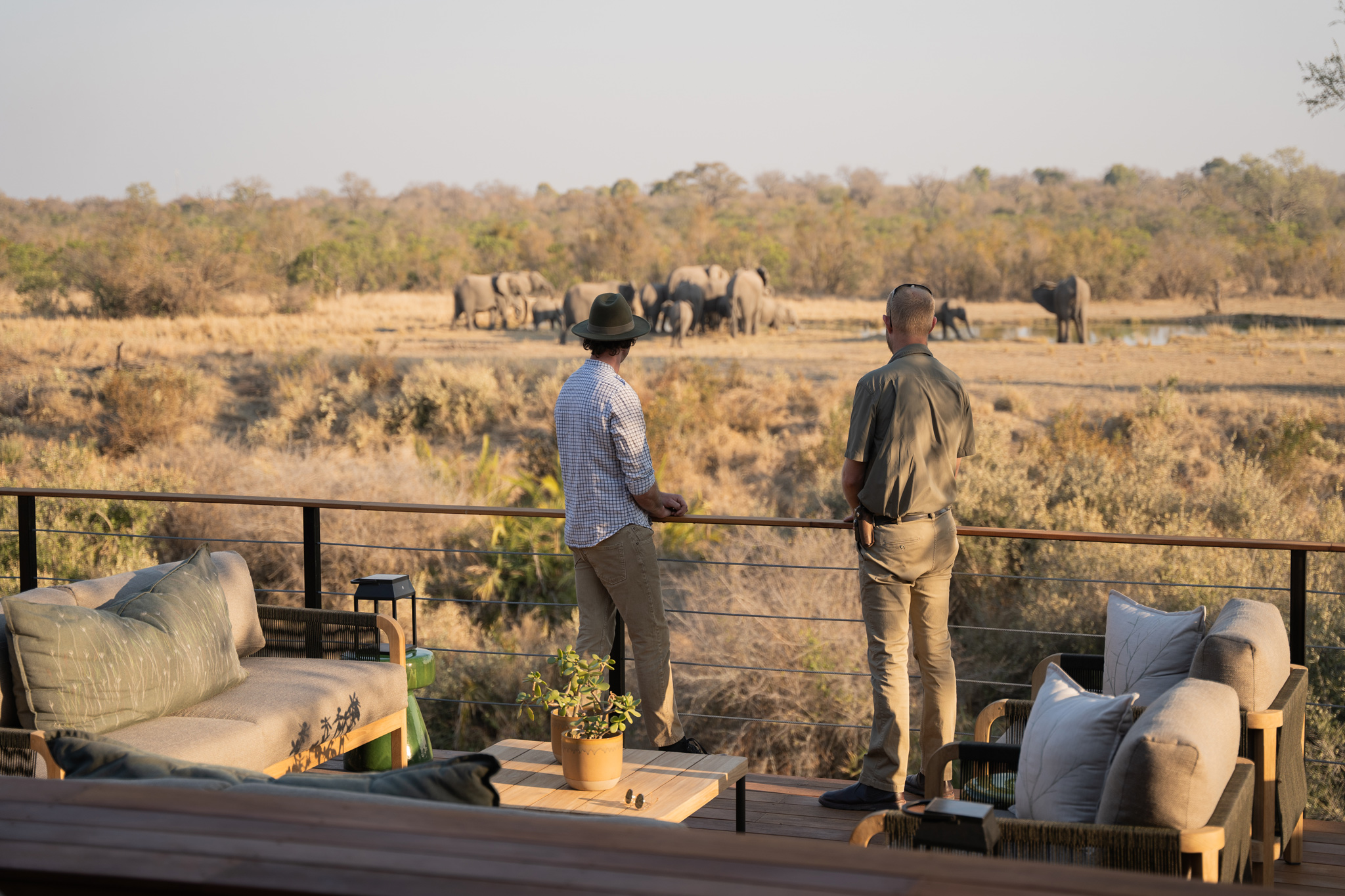 two guests on the viewing deck of thornybush camp looking at elephants by waterhole