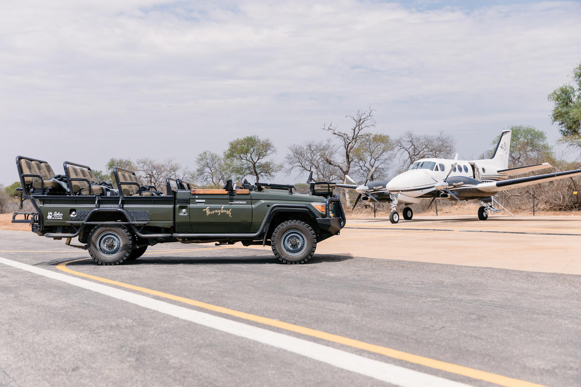 airoplane and safari vehicle on landing strip of thornybush