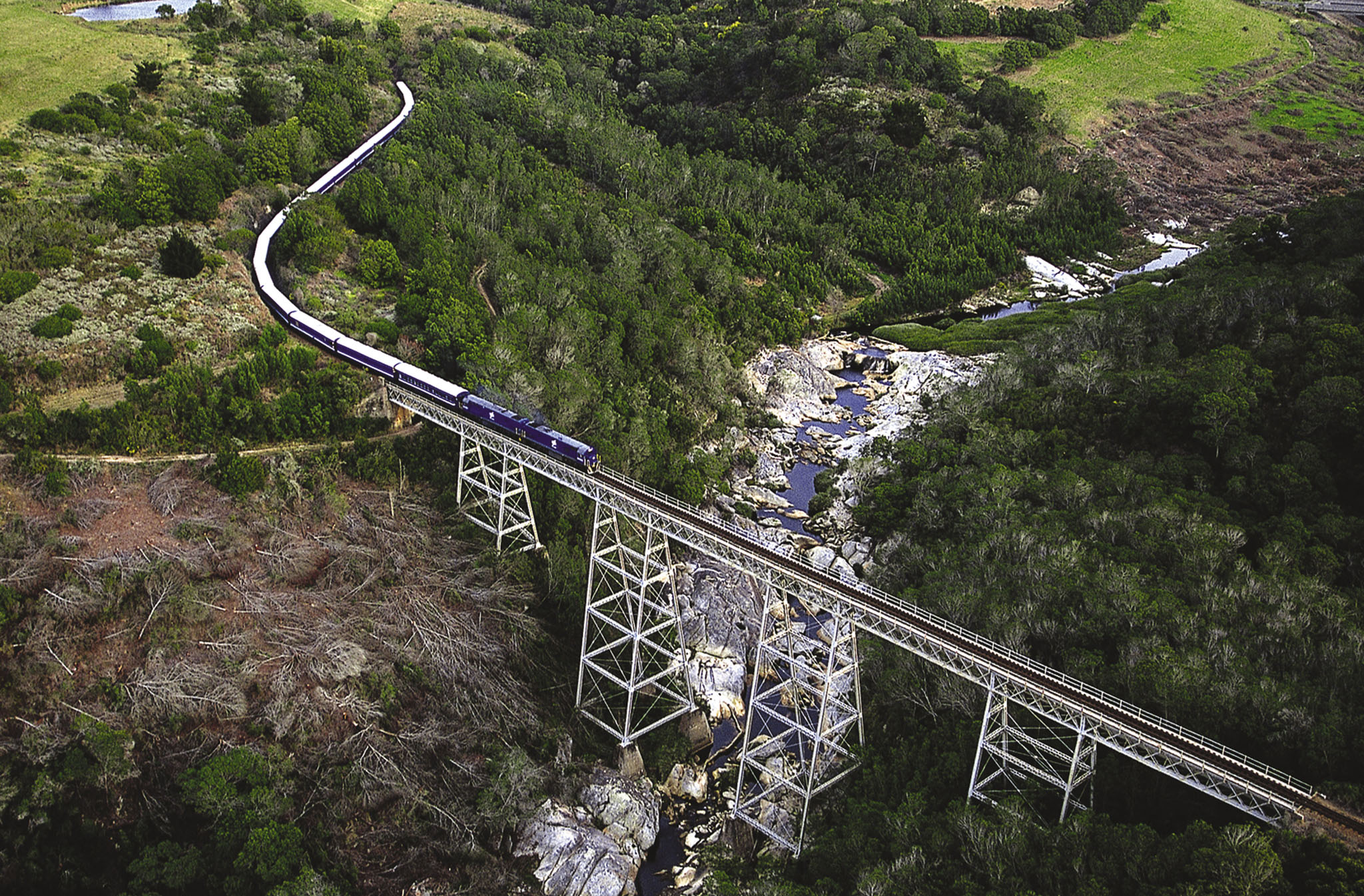 high bridge crossing with Blue Train on it and river below in the ravine