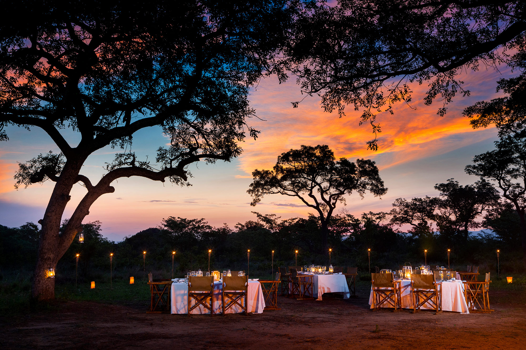 Bush Dinner at Ulusaba luxury safari lodge at night with sunset view in African bush