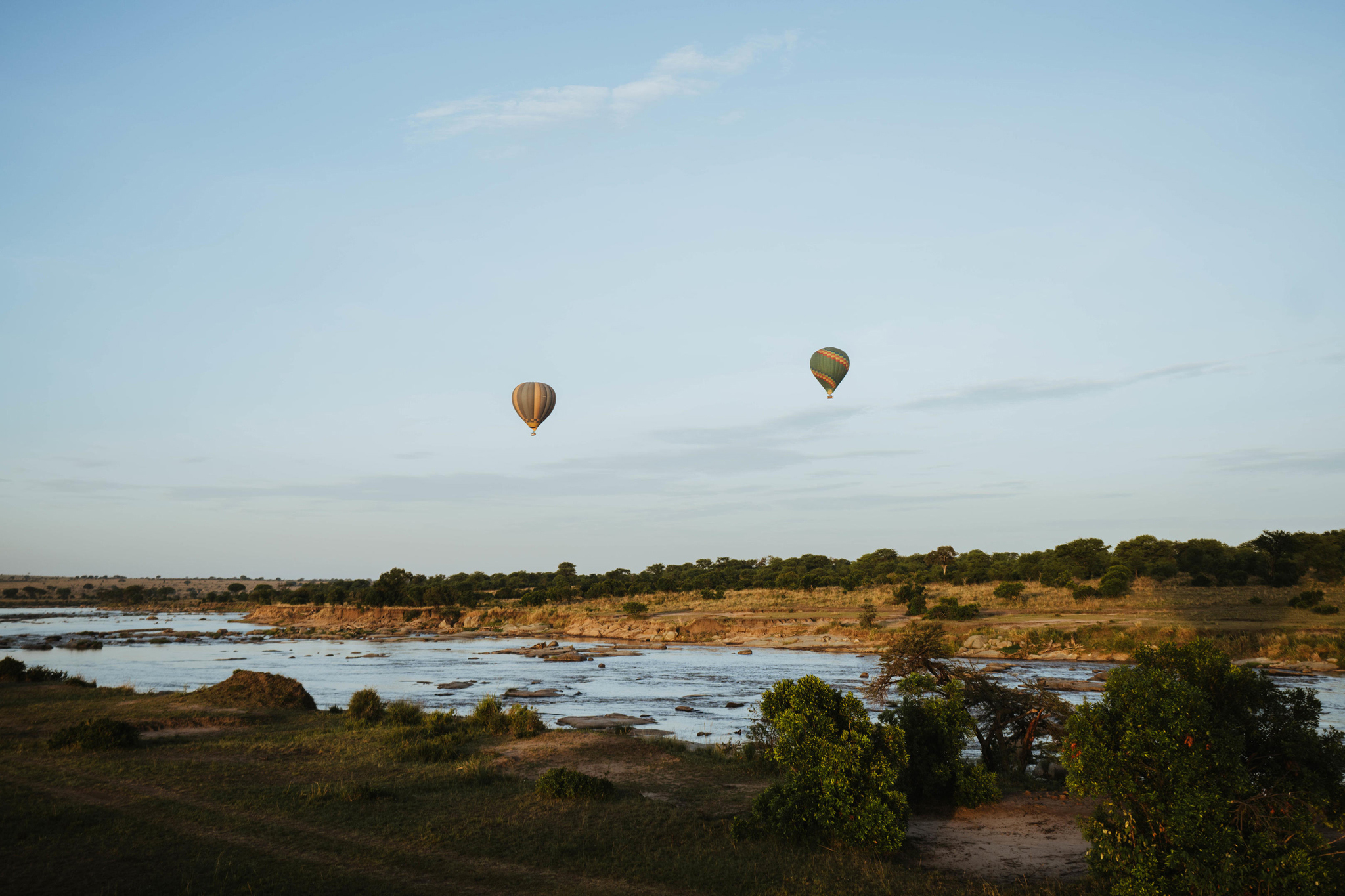 two hot air balloons over the river at Wilderness Usawa tented camp Serengeti