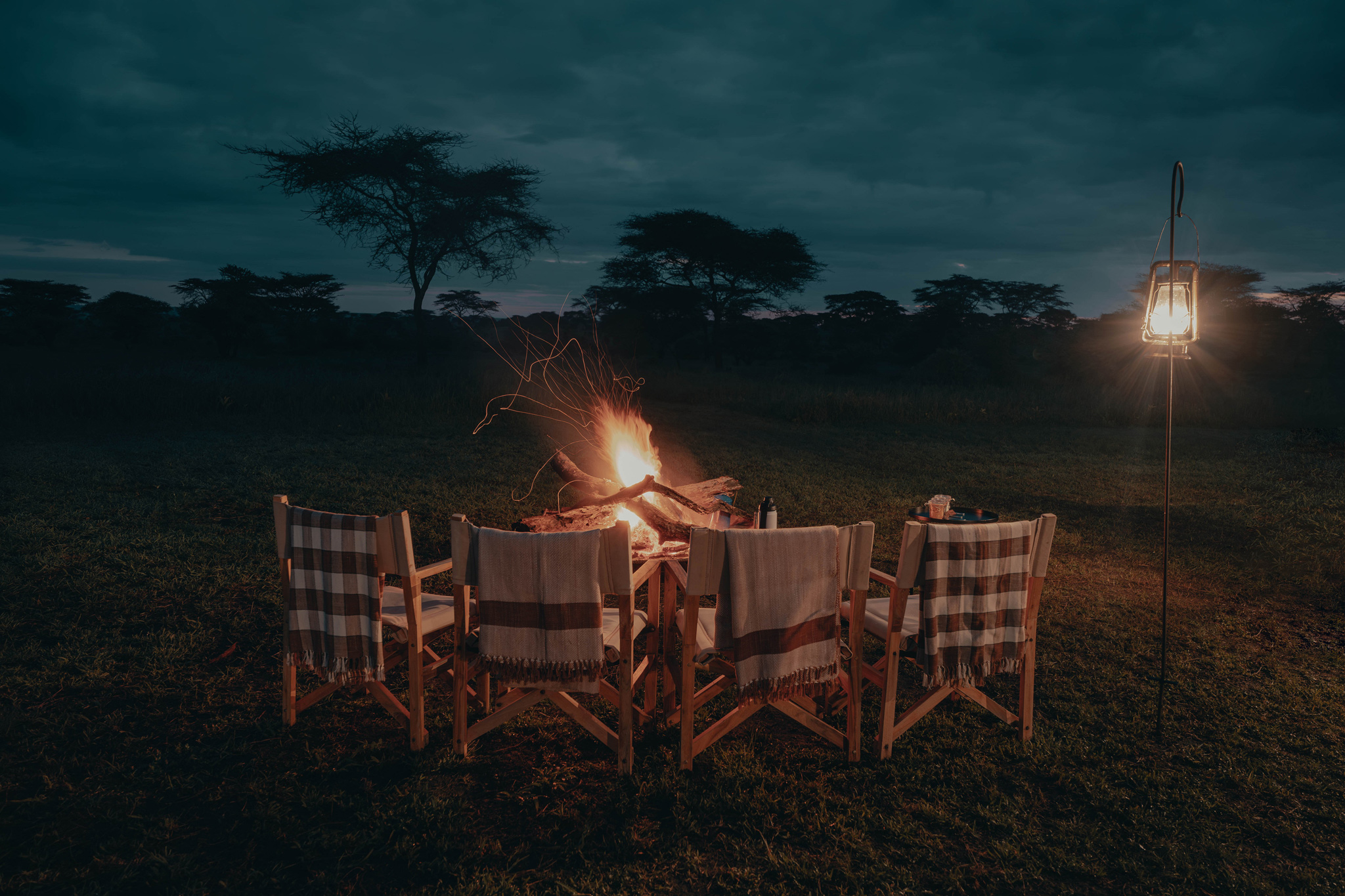 chairs around fireplace at Wilderness Usawa tented camp Serengeti