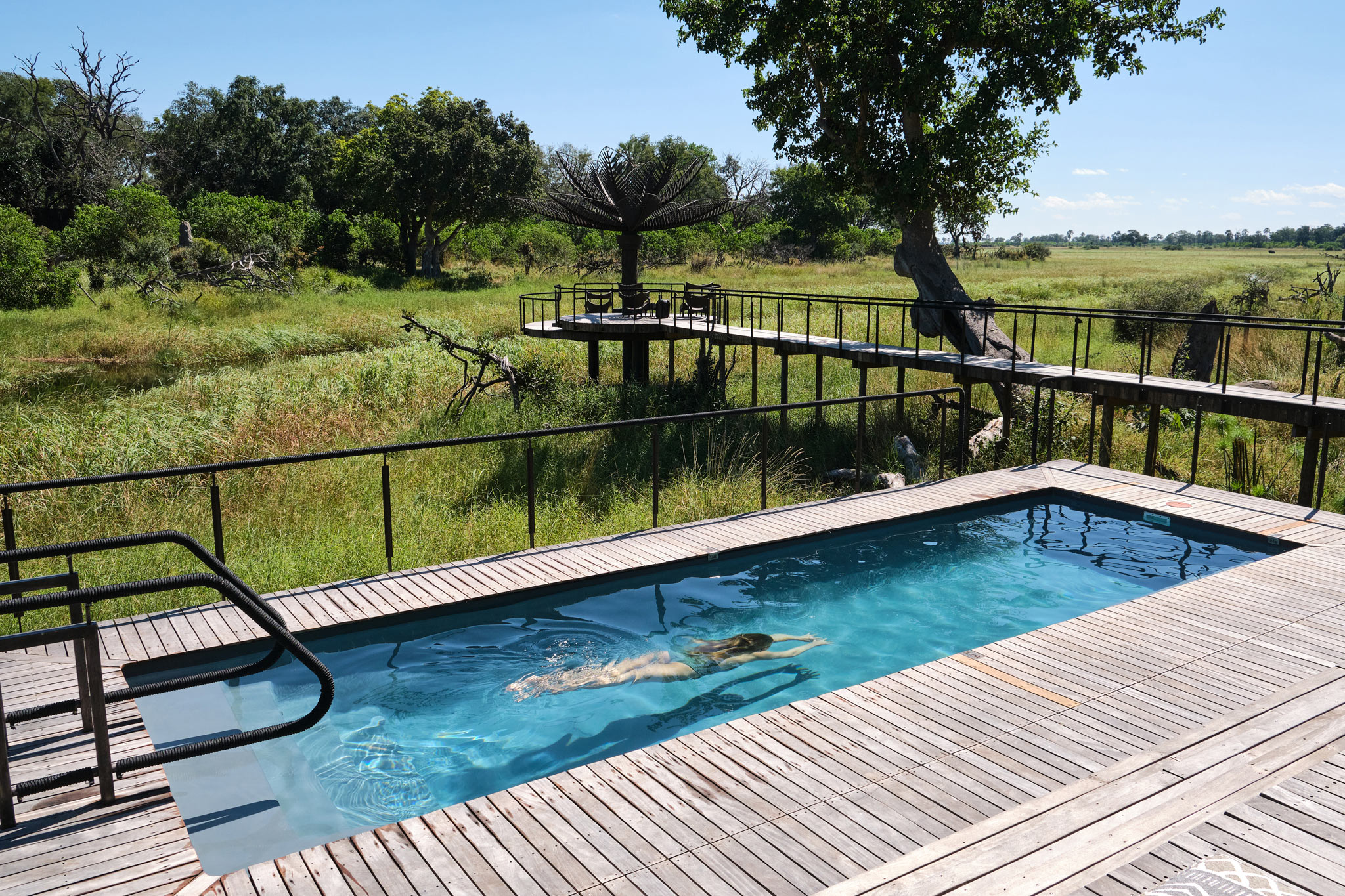 lady guest in main pool of Xigera Lodge Botswana