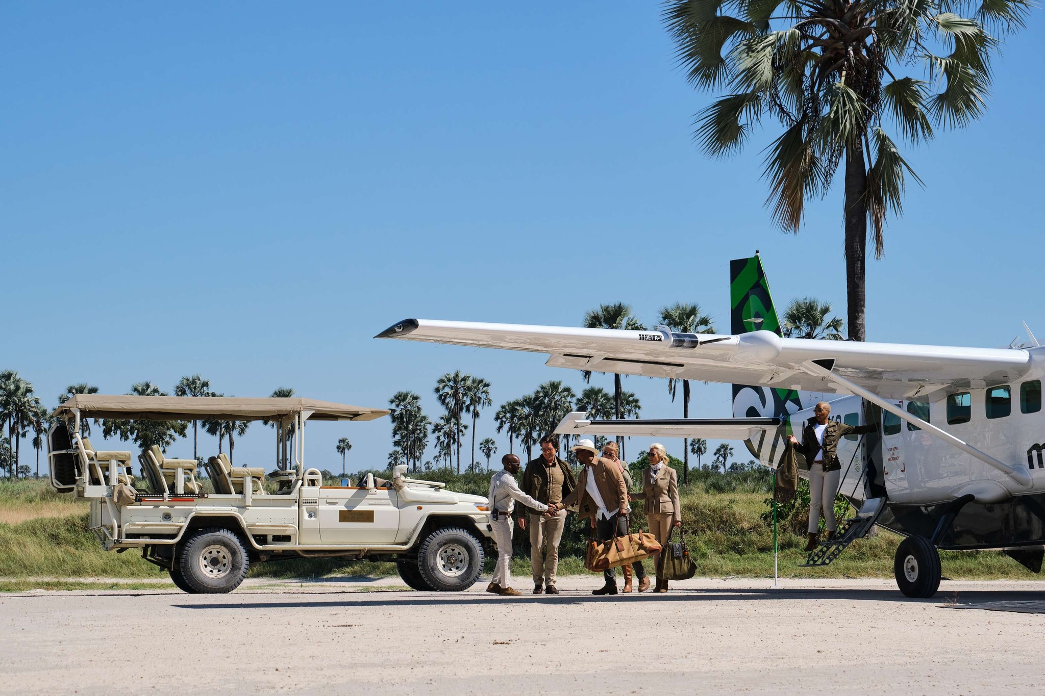 guests on private landing strip with plane and safari vehicle at Xigera safari lodge Okavango Delta Bostwana
